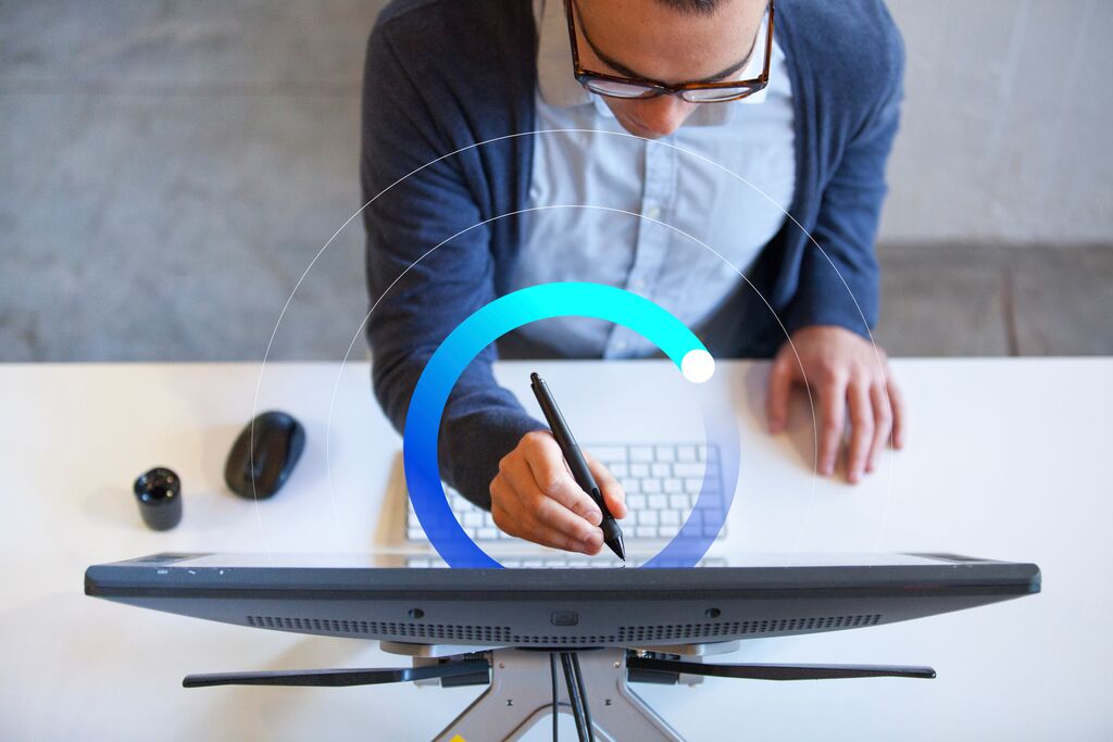 man holding stylus to touch up details on computer screen