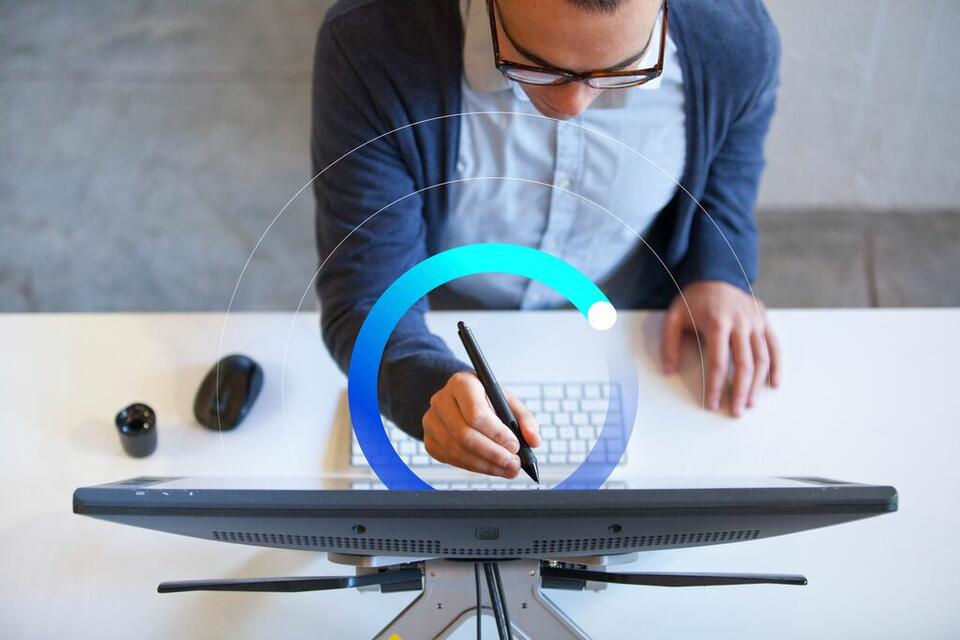 man holding stylus to touch up details on computer screen man holding stylus to touch up details on computer screen